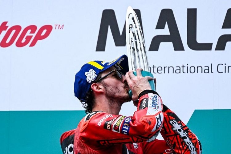 Francesco Bagnaia mencium trofi setelah meraih kemenangan di MotoGP Malaysia 2022 di Sirkuit Sepang, Minggu (23/10/2022). Bagnaia kini selangkah lagi dekat dengan titel juara dunia MotoGP 2022. Terkini, Francesco Bagnaia bakal melakukan selebrasi dengan menggunakan sepatu bot koboi seandainya menang di MotoGP Amerika 2023. (Foto oleh MOHD RASFAN/AFP)