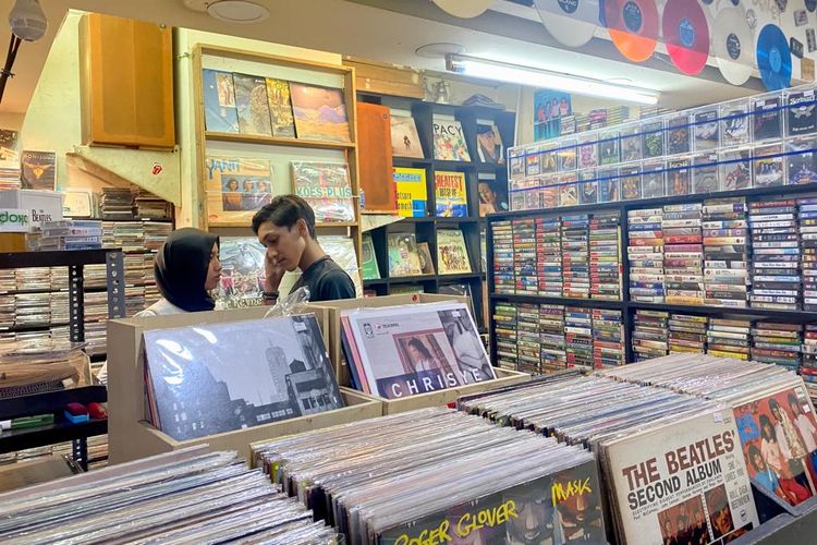 Pengunjung pasangan yang sedang mendengar musik jadul di pasar musik Blok M Square, Jakarta Selatan. 