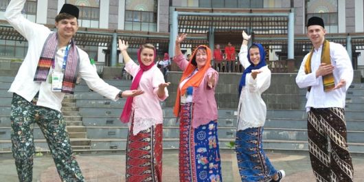 Atlet dan pelatih Asian Games asal Uzbekistan berfoto memakai baju adat Betawi saat berkunjung ke PBB Setu Babakan, Jakarta Selatan, Minggu (26/8/2018).