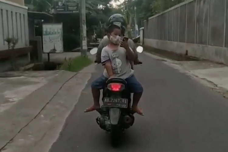 Video bocah dibonceng hadap belakang sambil main ponsel