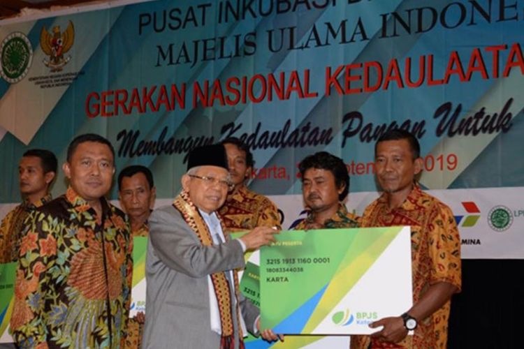 Eko Darwanto Dewan Pengawas BPJAMSOSTEK mendampingi Prof Dr Maaruf Amin menyerahkan kartu kepesertaan kepada petani.