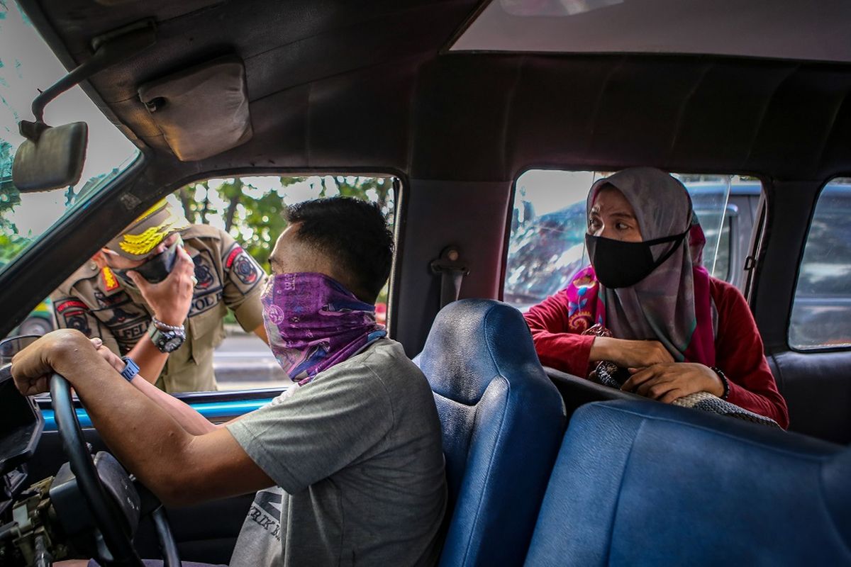 Petugas Satpol PP memberikan sosialisasi penerapan PSBB kepada pengendara di Jalan Daan Mogot, Tangerang, Banten, Selasa (14/4/2020). Menteri Kesehatan menyetujui menerapkan Pembatasan Sosial Berskala Besar (PSBB) di Tangerang Raya yang akan mulai diterapkan pada Sabtu (18/4) dalam rangka percepatan penanganan COVID-19. ANTARA FOTO/Fauzan/hp.