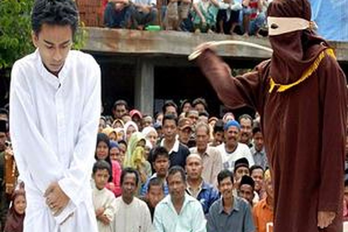 Ilustrasi: Seorang warga Indonesia dicambuk di depan umum karena berjudi. 