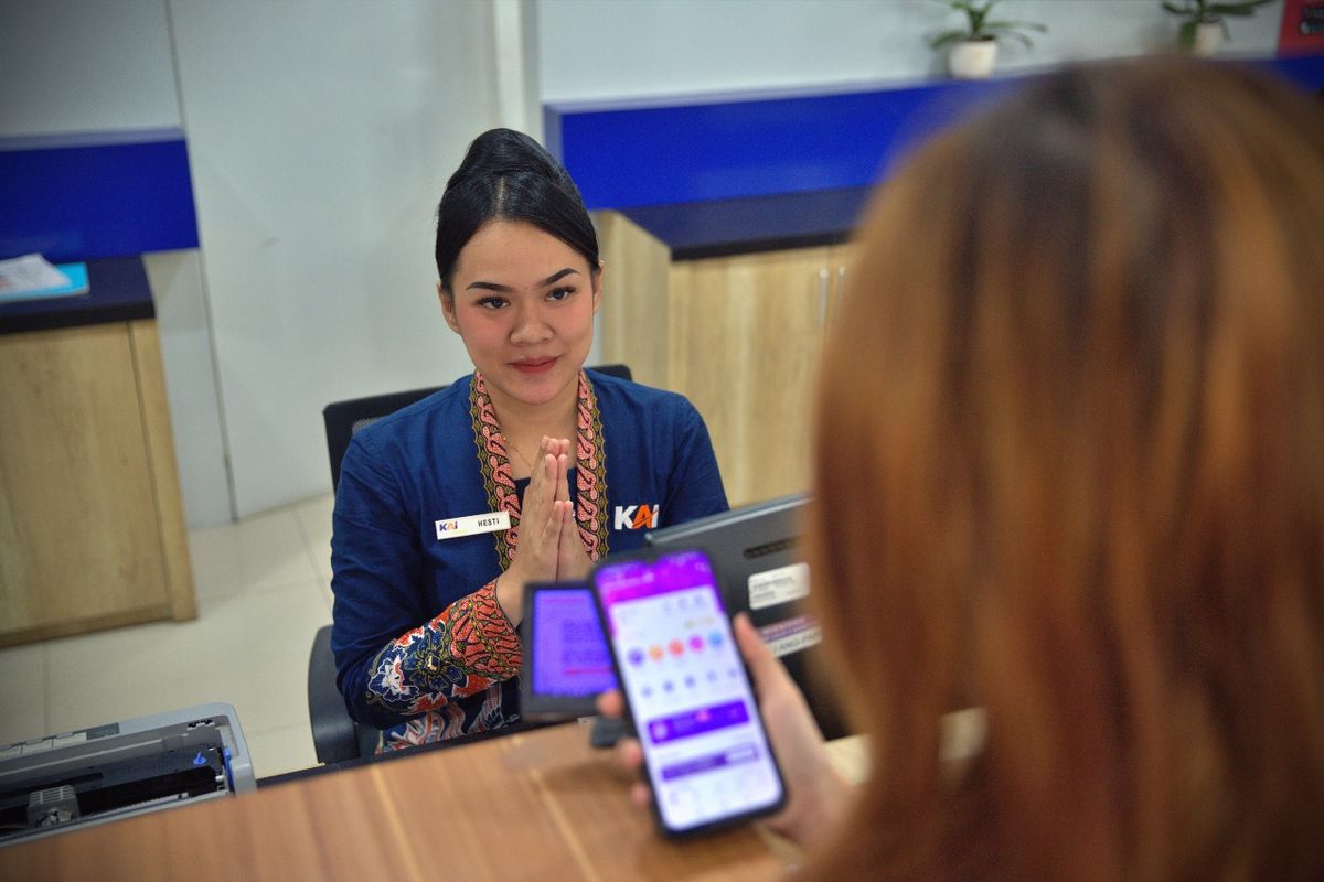 Ilustrasi pegawai KAI berinteraksi dengan pelanggan.