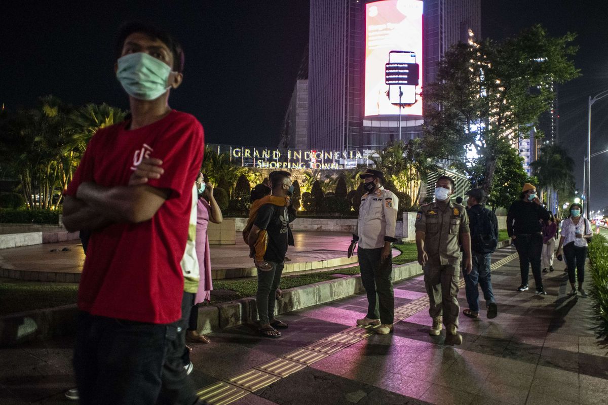 Petugas Satpol PP DKI Jakarta membubarkan warga yang berkumpul saat berlangsungnya Crowd Free Night di kawasan Bundaran HI, Jakarta, Jumat (31/12/2021). Polda Metro Jaya memberlakukan pengendalian mobilitas Crowd Free Night (malam bebas keramaian) pada malam tahun baru 2022 yang berlangsung mulai pukul 22.00 - 04.00 WIB.