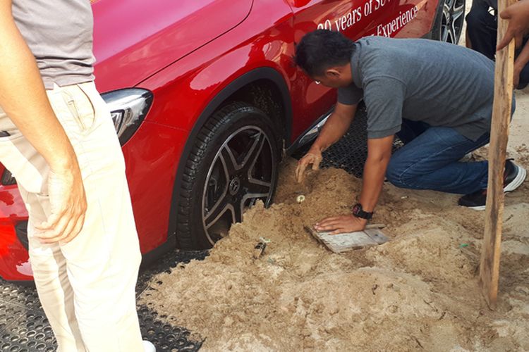 Ilustrasi ban mobil terjebak di dalam pasir pantai