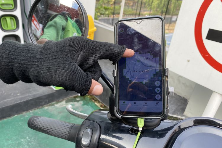 Seorang driver ojek online menunjukkan titik-titik lokasi penggantian baterai motor listrik, persebarannya dinilai masih sedikit