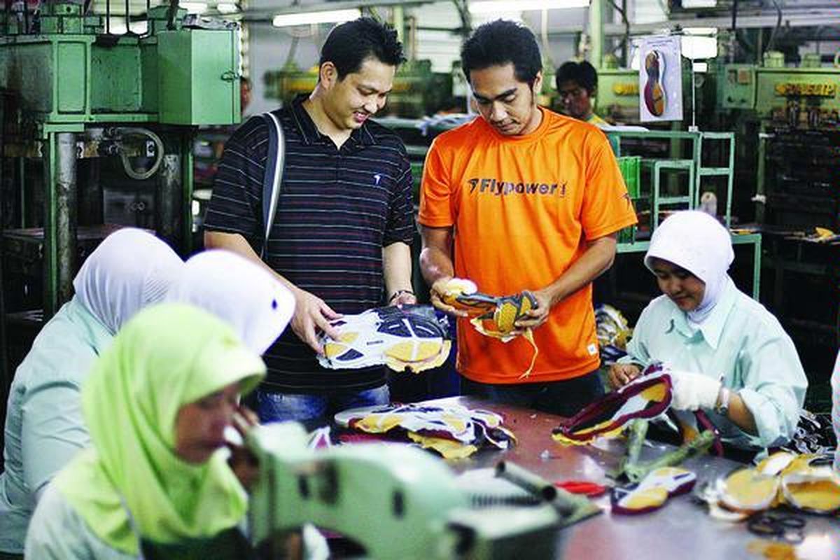 Hariyanto Arbi (kiri, berdiri) dan Wahyu Agung Setyawan, mantan pebulu tangkis yang kini mendirikan Flypower, perusahaan peralatan bulu tangkis nasional, mengecek sepatu edisi terbarunya di Pabrik Adetex, Bandung, Jawa Barat, Kamis (11/3). Dalam seminggu, pabrik tersebut memproduksi 1.400 pasang sepatu dan menargetkan 20.000 per bulan. Sepatu produksinya sudah diekspor ke Perancis, Malaysia, Brunei Darussalam, dan Filipina.