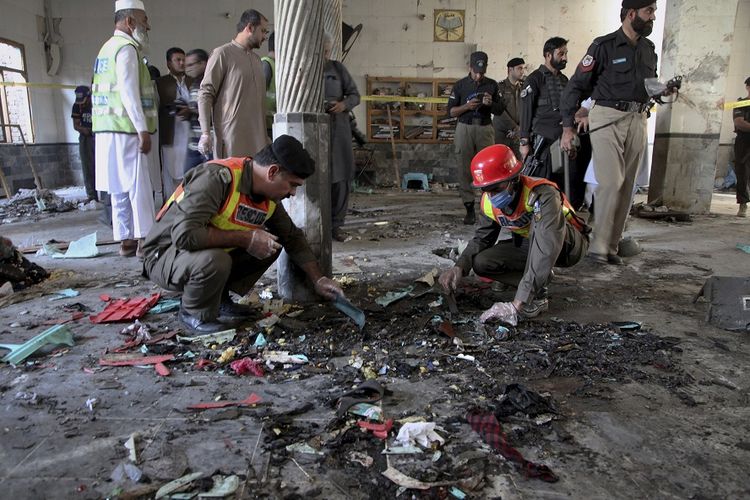 Petugas penyelamat dan polisi memeriksa lokasi ledakan bom di sebuah pesantren di Peshawar, Pakistan, Selasa (22/10/2020). Ledakan bom dahsyat tersebut menewaskan beberapa siswa dan melukai puluhan lainnya, kata polisi dan juru bicara rumah sakit.