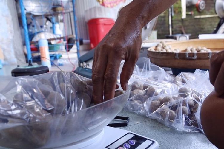 Rosida sedang menimbang bakso hasil buatannya. 