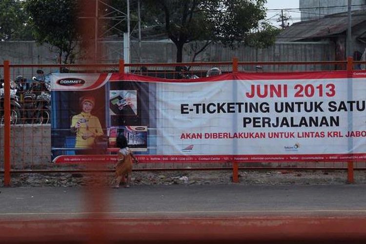 Penumpang melintas di depan spanduk sosialisasi pemberlakuan E-Tiket di Stasiun Palmerah, Jakarta Pusat, Minggu (19/5/2013). Pemberlakuan tarif baru bersamaan dengan pemberlakuan E-Tiket yang dimulai per 1 Juni itu diharapkan dapat meningkatkan jumlah pengguna KRL. 
