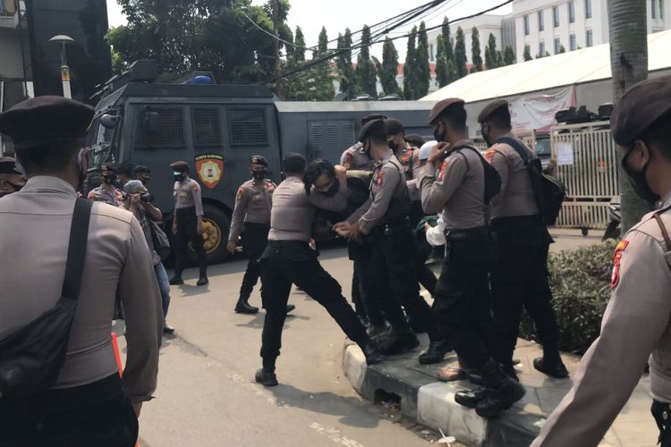 Anggota kepolisian menangkap satu orang simpatisan Rizieq Shihab saat kericuhan terjadi di depan Pengadilan Negeri Jakarta Timur, Cakung, Jakarta Timur pada Jumat (26/3/2021) siang.