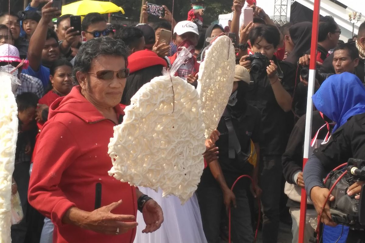 Raja Dangdut Rhoma Irama mengikuti lomba makan kerupuk dalam acara Konser Kemerdekaan Republik Indonesia ke-73, di Partai Carnaval, Ancol, Jakarta Utara, Sabtu (18/8/2018).