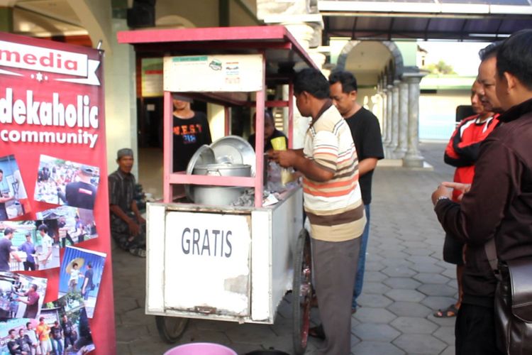 Relawan Sedekaholic, saat membagi bubur gratis. KOMPAS.Com / Slamet Priyatin