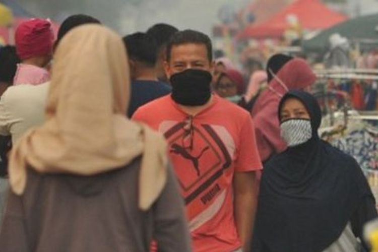 Warga beraktivitas saat hari bebas kendaraan yang diselimuti kabut asap tipis di Telanaipura, Jambi, Minggu (18/08). Kota Jambi kembali diselimuti kabut asap dalam beberapa hari terakhir, dan bertambah pekan terakhir. 