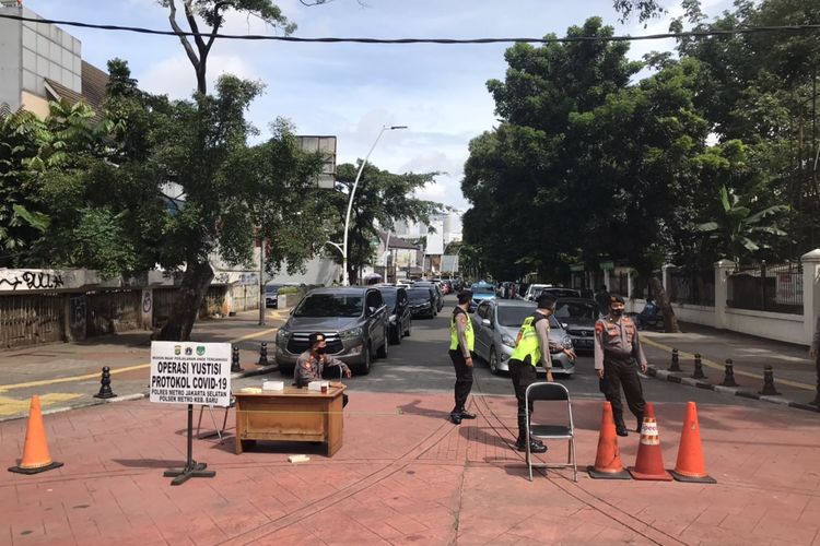 Aparat kepolisian berjaga di Jalan Bulungan Raya, Kramat Pela, Kebayoran Baru, Jakarta Selatan pada Rabu (24/2/2021) pagi. Presiden Jokowi direncanakan hadir dalam acara vaksinasi guru di SMAN 70 Jakarta