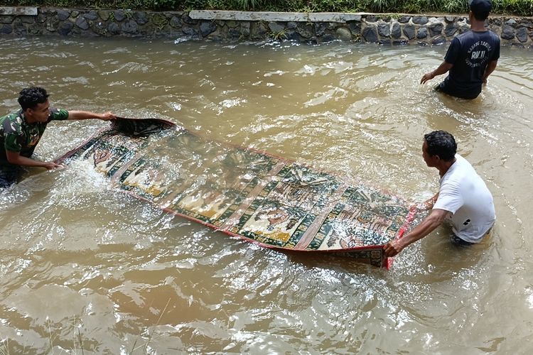 Warga Kampung Pojok, Desa Cigondewah Hilir, Kecamatan Margaasih, Kabupaten Bandung, Jawa Barat saat membersihkan karpet di DAS Ciwidey, kegiatan tersebut merupakan tradisi turun temurun yang sudah dilakukan sejak lama, Kamis (7/3/2024)