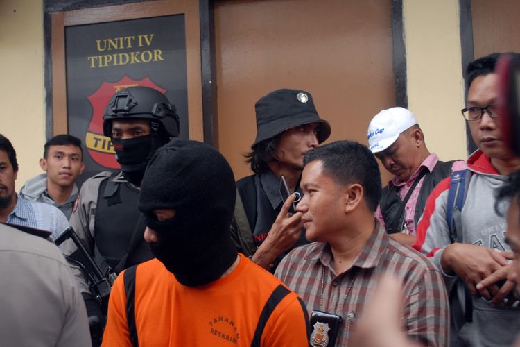 Tersangka tindak pidana korupsi, HR (mengenakan tutup kepala) saat dihadirkan pada jumpa pers di Polres Sukabumi Kota, Sukabumi, Jawa Barat, Selasa (6/6/2017). 