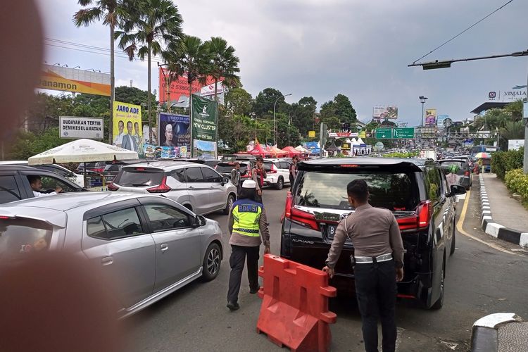 Anggota Satlantas Polres Bogor, Aipda Desi Apriyanti saat mengurai kepadatan arus kendaraan dari arah Jakarta di pintu keluar tol Ciawi Simpang Gadog, Puncak Bogor, pada Senin (24/4/2023) pukul 14.00 WIB.