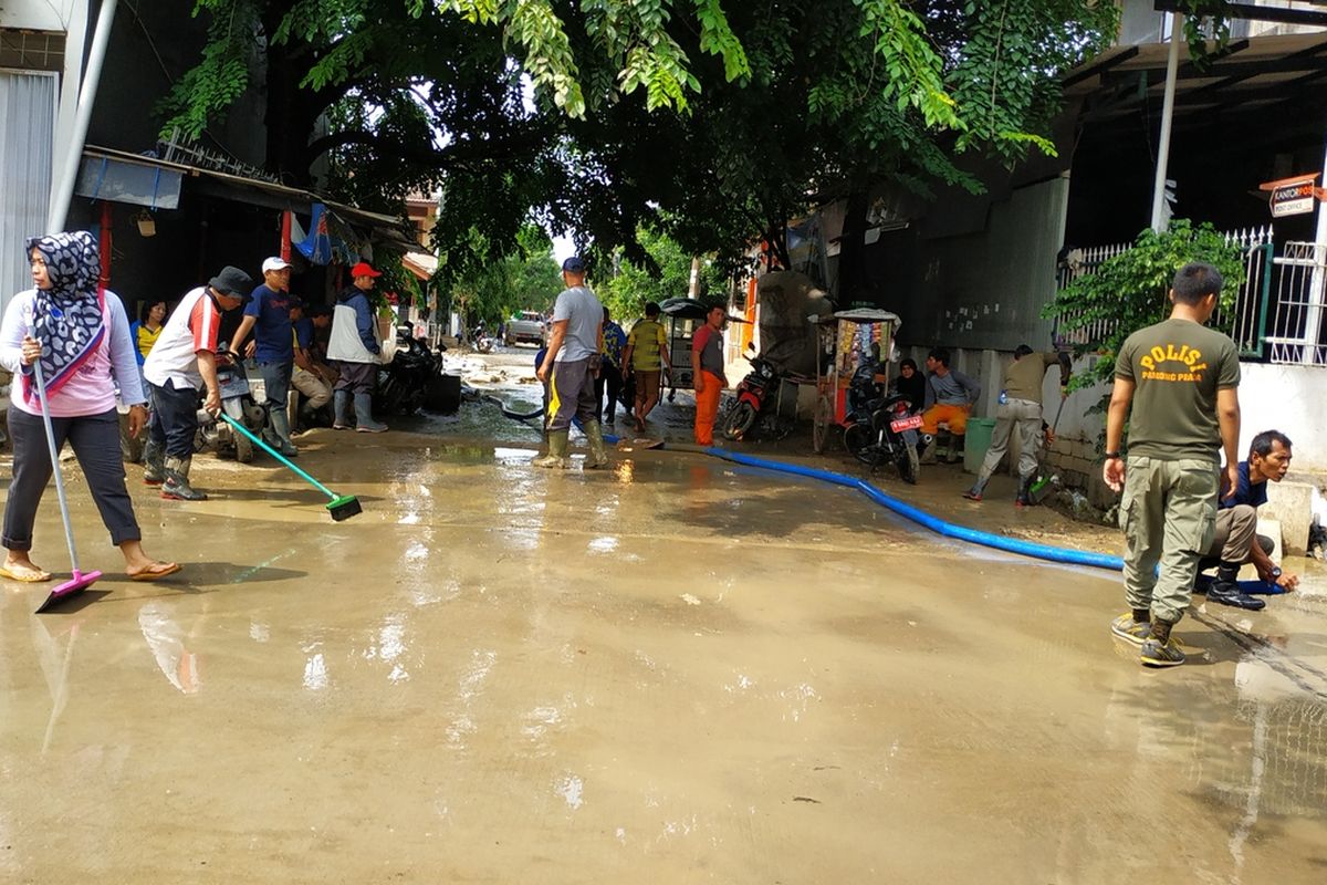 Warga dan staf Pemerintah Kota Bekasi kerja bakti membersihkan lumpur sisa banjir yang masih memenuhi jalan-jalan Perumahan Kemang Ifi, Jatiasih, Kota Bekasi, selepas berakhirnya masa tanggap darurat bencana banjir, Rabu (15/1/2020).