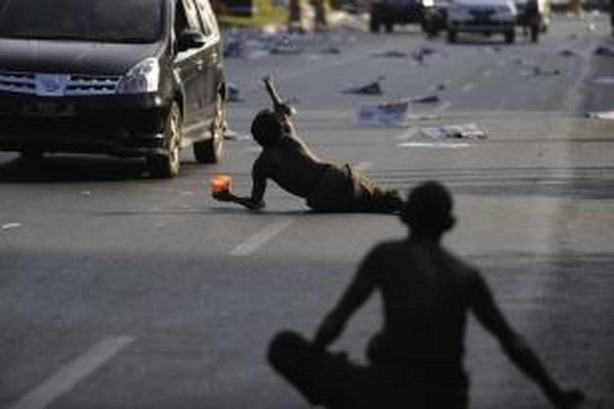 Pengemis menunggu pemberian hingga ke tengah jalan demi mendapatkan sedekah dari pengendara yang melintas di Jalan Pahlawan, Kota Semarang, Jawa Tengah, Minggu (19/8/2012). Lebaran juga menjadi momentum berbagi bersama warga miskin dengan memberikan zakat.  