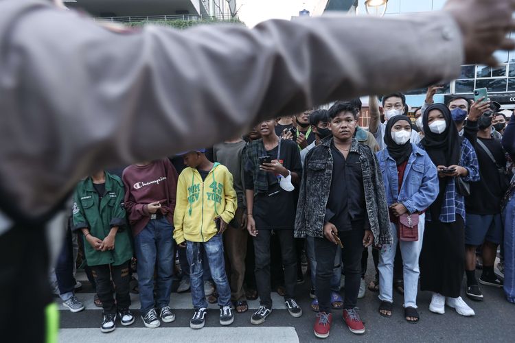 Pengunjung menunggu menyaksikan peragaan busana jalanan di kawasan Dukuh Atas, Jakarta, Rabu (20/7/2022).  Fenomena Citayam Fashion Week di kawasan Dukuh Atas mendadak viral karena gaya busana nyentik yang didominasi anak muda dari Depok, Citayam, dan Bojonggede.