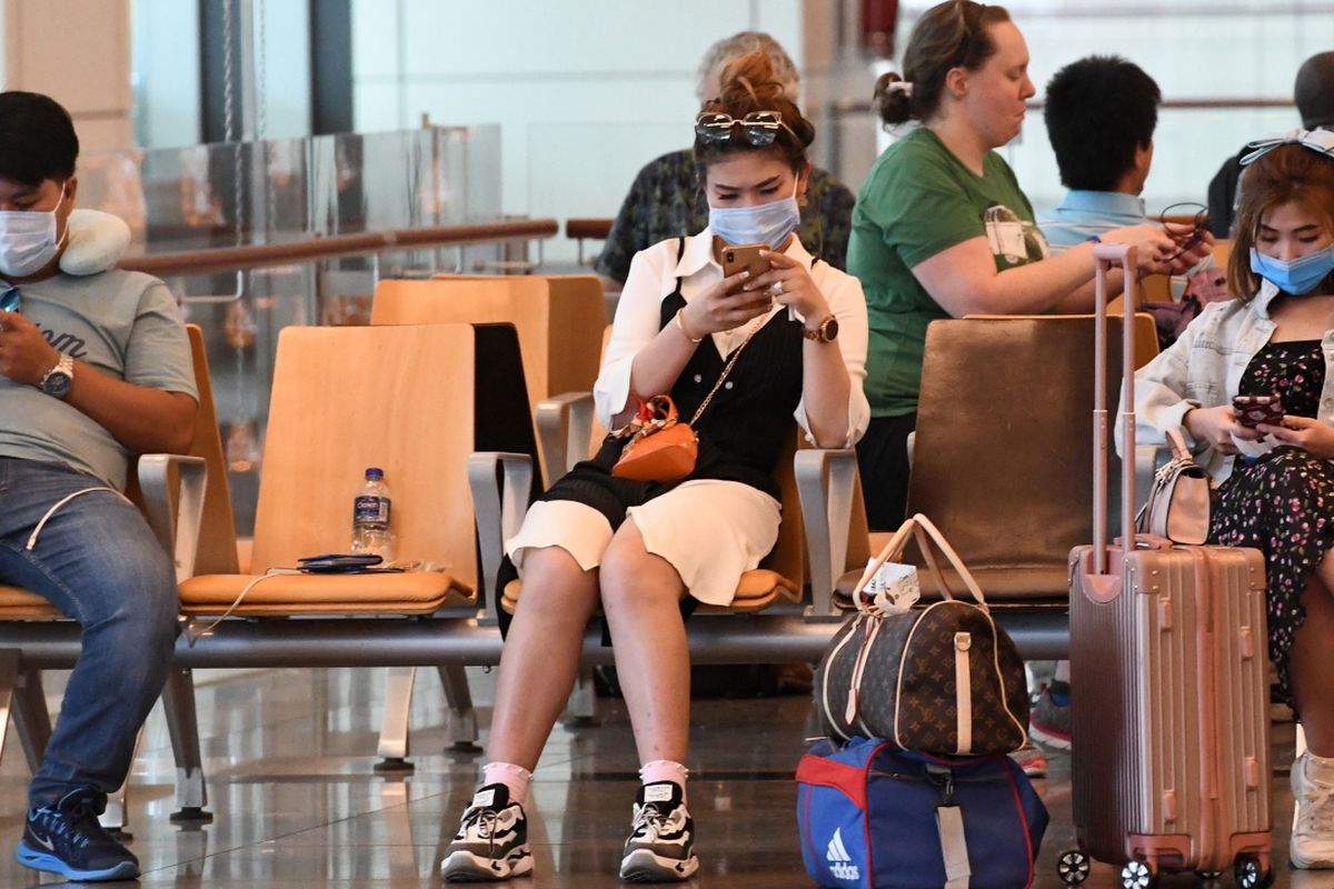Penumpang mengenakan masker untuk melindungi diri dari penyebaran Covid-19 coronavirus, saat menunggu penerbangan di Bandara Internasional Changi, di Singapura, 27 Februari 2020