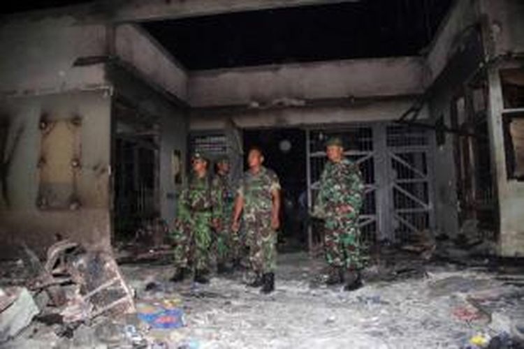 Anggota TNI memeriksa puing kebakaran pasca-kerusuhan di Lapas Labuhan Ruku, Kabupaten Batubara, Sumatera Utara, 19 Agustus 2013. Sebanyak 30 narapidana melarikan diri dari lapas tersebut.