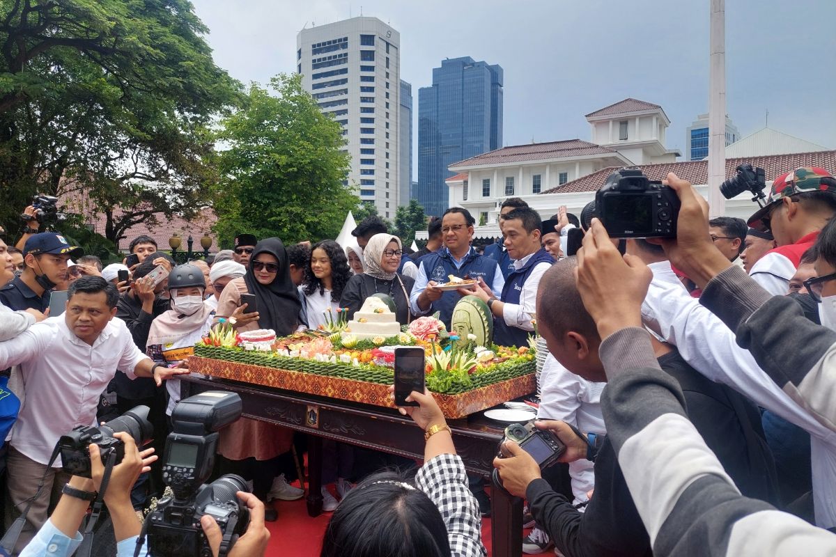 Gubernur DKI Jakarta Anies Baswedan saat memberikan potongan nasi tumpeng kepada Wakil Gubernur DKI Jakarta Ahmad Riza Patria dalam acara perpisahan bertajuk Terima Kasih Jakarta di Balai Kota DKI Jakarta, Jakarta Pusat, Minggu (16/10/2022) siang.