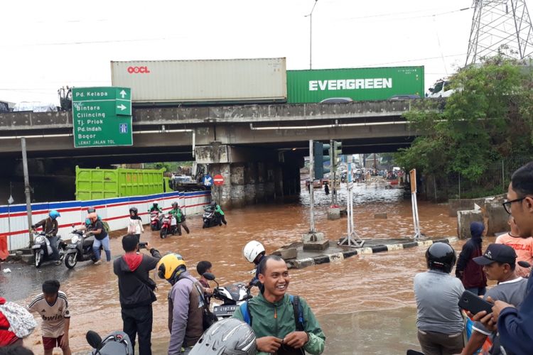 Tampak Banjir setinggi lutut orang dewasa menggenang di kolong Tol JORR Jalan KH.Noer Ali, Bekasi Barat, Kota Bekasi, Selasa (30/10/2018).