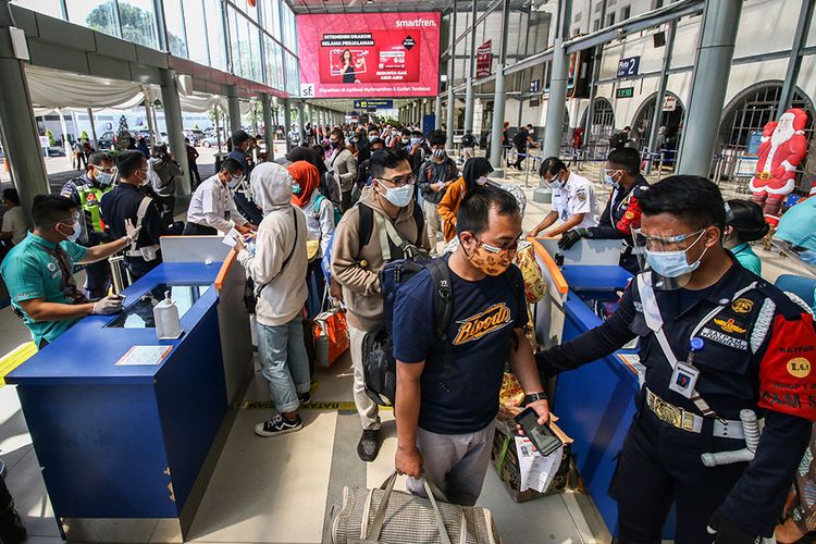 Penumpang antre untuk memasuki area peron di  memasuki Stasiun Pasar Senen, Jakarta, Jumat (25/12/2020).  PT Kereta Api Indonesia telah menjual 428.000 tiket KA untuk periode masa libur Natal dan Tahun Baru 2021 keberangkatan 18 Desember 2020 - 6 Januari 2021.