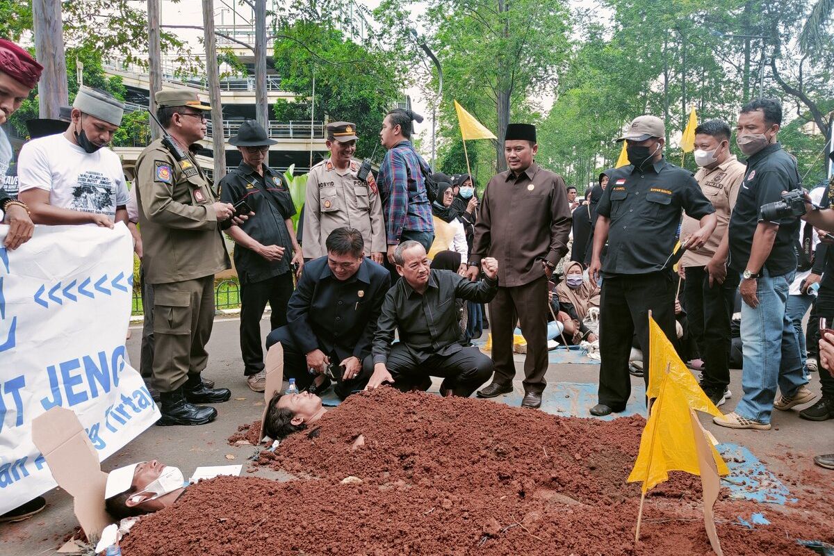 Demonstran melakukan aksi kubur diri tolak relokasi makam Syekh Buyut Jenggot di depan Gedung Balai Kota Tangerang, Kamis (29/9/2022). Dewan Perwakilan Rakyat Daerah (DPRD) Kota Tangerang mendukung penolakan relokasi itu dan membantu penetapannya sebagai cagar budaya.