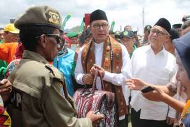 Menteri Agama RI, Lukman Hakim Saifuddin saat menerima kenang-kenangan dari masyarakat berupa syal dan tas khas kerawang Gayo Lues di sekitar stan pameran expo madrasah IV Porseni XV Aceh di Lapangan Musara Alun, Takengon, Aceh Tengah, Kamis (4/8/2016).