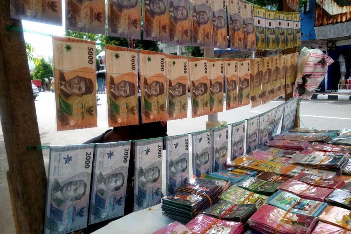 Penjaja jasa penukaran uang memajang uang kertas pecahan Rp 20.000, Rp 10.000, Rp 5.000, dan Rp 2.000 di lapaknya, Jalan Merdeka, Kota Blitar, Jumat (21/3/2025).