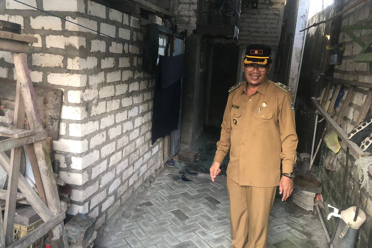 Kepala Desa Campurejo Amudi, ketika menunjukkan salah satu rumah di Dusun Karangtumpuk, Desa Campurejo, Gresik, Jawa Timur, yang berdiri di atas lahan wilayah Kabupaten Gresik dan Lamongan.