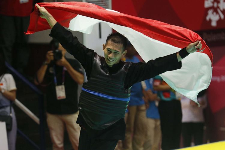 Pesilat Indonesia Iqbal Candra Pratama (sabuk biru)melakukan selebrasi usai mengalahkan pesilat Vietnam Ngoc Toan Nguyen dalam babak final Kelas E Putra Asian Games 2018 di Padepokan Pencak Silat Taman Mini Indonesia Indah (TMII), Jakarta, Senin (27/8/2018). Candra berhasil meraih medali emas cabang olahraga pencak silat kelas 60-65 kilogram.