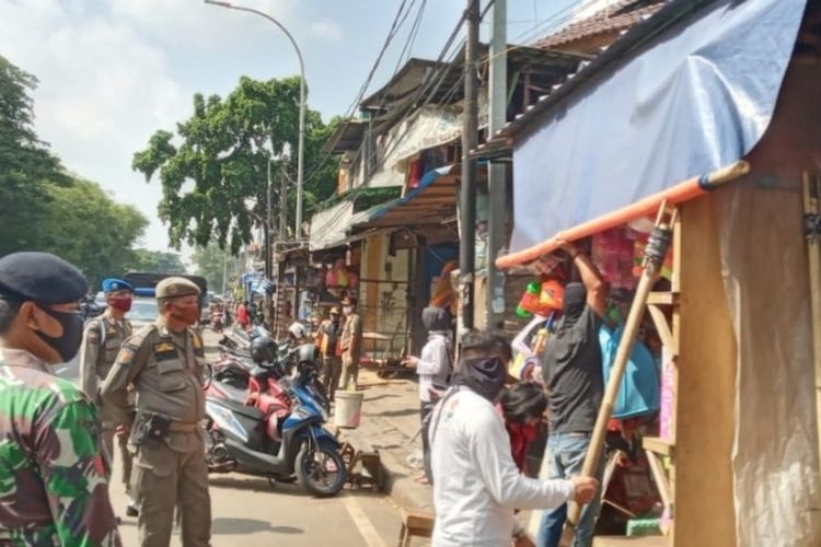 Satpol PP saat menertibkan sejumlah toko di Pasar Gembrong, Jakarta Timur yang masih beroperasi saat PSBB, Selasa (2/6/2020).