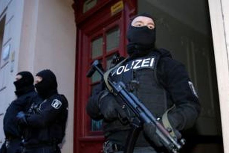 Anggota satuan polisi anti-teror Jerman bersiaga di sebuah bangunan yang digerebek dalam sebuah operasi ant-teror di Berlin, Jumat (16/1/2015) dini hari. 