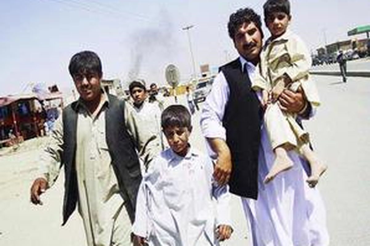 Lelaki dan perempuanAfganistan meninggalkan tempat terjadinya bommobil, di pinggiran kota Kabul, Selasa (18/8). Sebuah mobil pengebom bunuh diri menyerang konvoi pasukan NATO,menewaskan setidaknya 7warga sipil dan mencederai 50 orang.