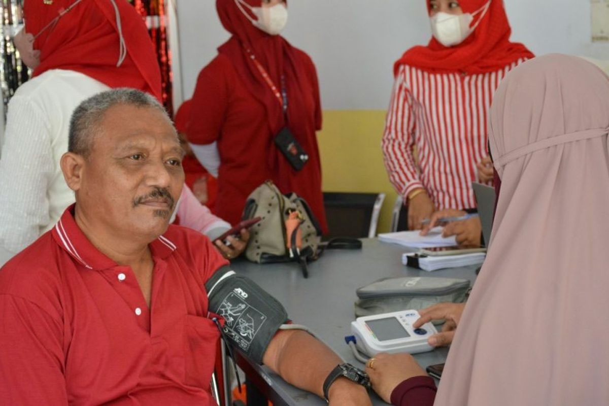 Seorang petugas kesehatan mengukur tekanan darah warga kota Gorontalo di arena pencanangan Germas dan vaksinasi booster dosis kedua bagi tenaga kesehatan. Pemeriksaan ini sebagai upaay skrining penyakit tidak menular.