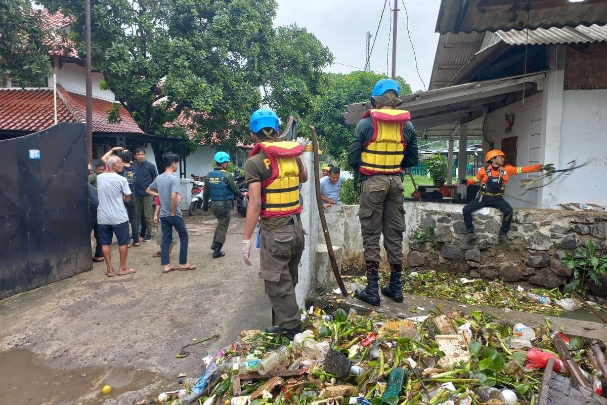 Tim SAR gabungan tengah berupaya mencari MSH (32), pegawai rumah makan yang tenggelam di aliran kali Sasak, Kedaung, Ciputat, Selasa (5/12/2023). Tim tampak tengah mengangkut sampah yang tersangkut di kolong jembatan. 