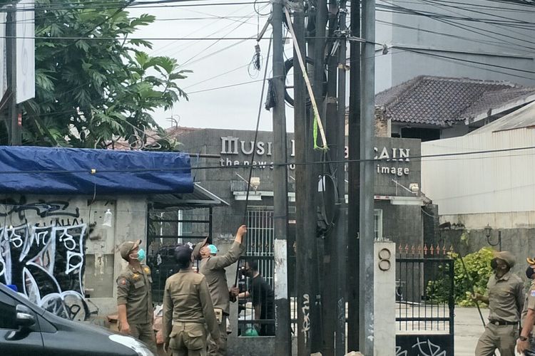 Satuan Polisi Pamong Praja (Satpol PP) Jakarta Selatan mencopot sejumlah atribut organisasi masyarakat (ormas) di sepanjang Jalan RS Fatmawati, Pondok Labu, Cilandak, Jakarta Selatan, Selasa (30/11/2021).