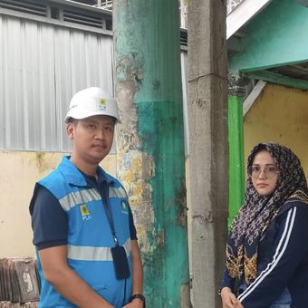 Pemilik rumah ada tiang listrik di terasnya, Siti Kotijah (kanan) bersama karyawan PLN