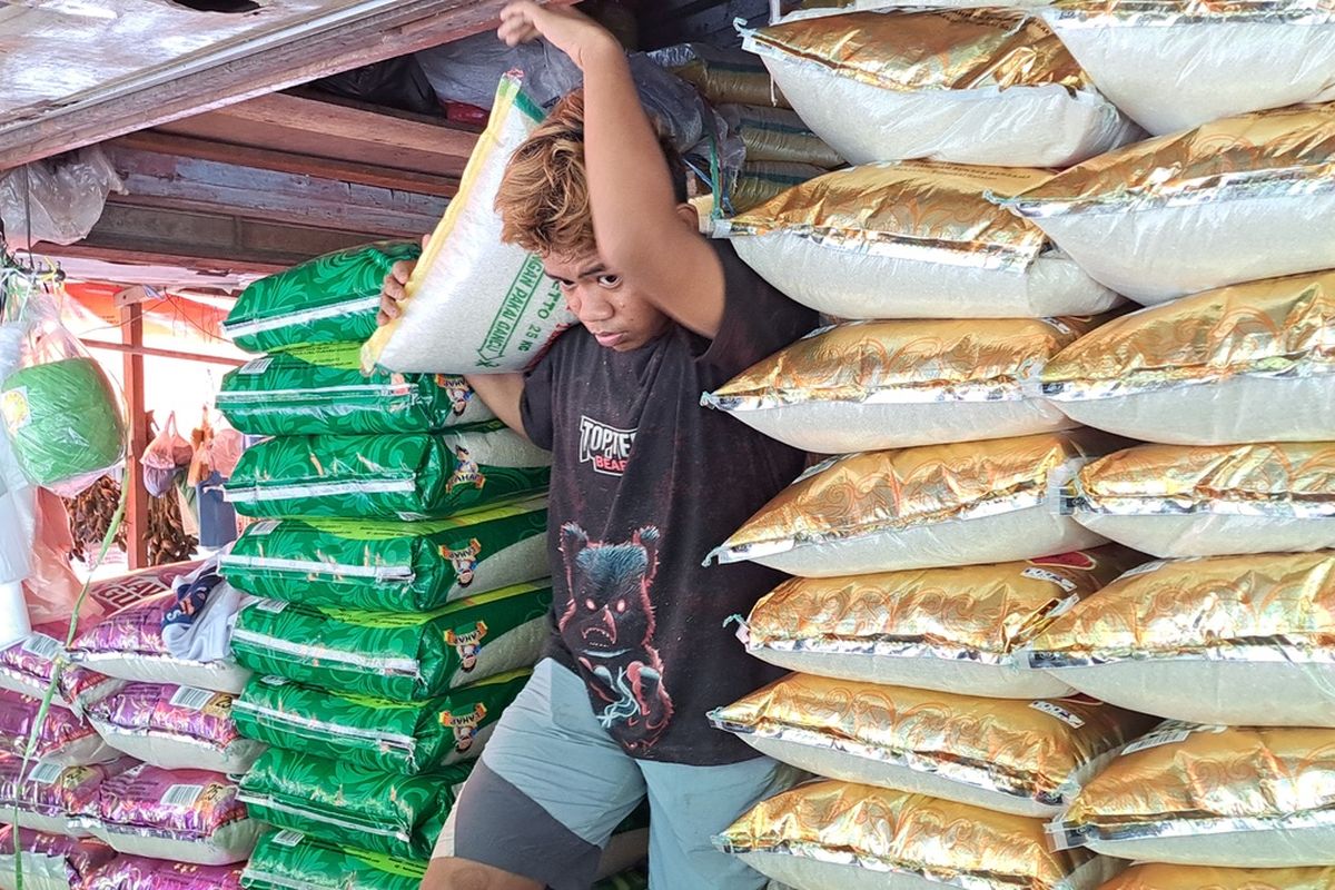 Pegawai toko beras di Pasar Terong Makassar, Sulsel saat mengangkat beras untuk pelanggannya, Selasa (13/2/2024)