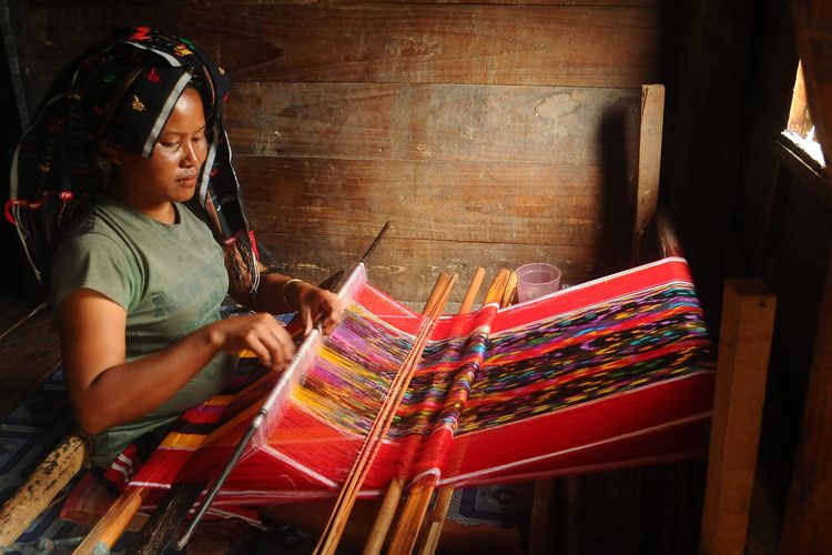 Ilustrasi pembuatan kain ulos dengan alat tenun tradisional 