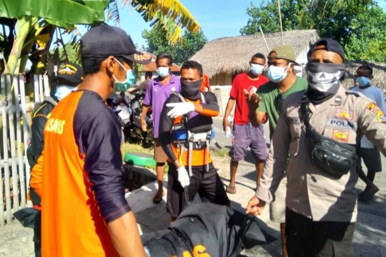 Foto: Aparat kepolisian dan tim basarnas sedang menggotong jasad korban menuju Puskesmas Maubasa, Kecamatan Ndori, Kabupaten Ende. 