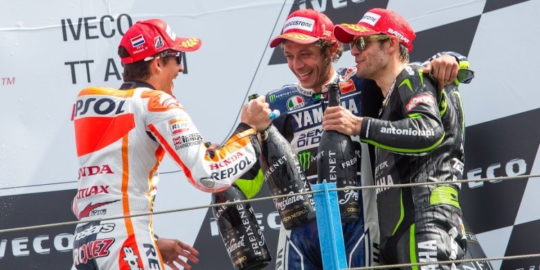 Pebalap Italia, Valentino Rossi (tengah) merayakan kemenangannya bersama Marc Marquez (kiri) dan Cal Crutchlow di podium GP Belanda, Sabtu (29/6/2013).