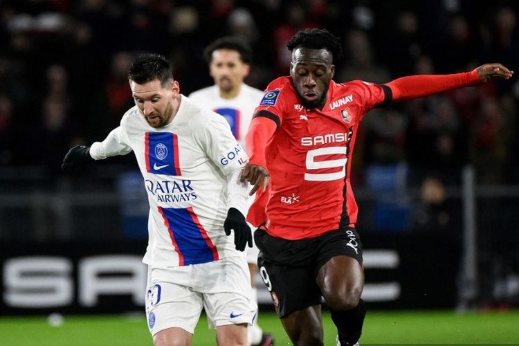 Lionel Messi (kiri) berduel dengan Arnaud Kalimuendo dalam laga pekan ke-19 Liga Perancis antara Rennes vs PSG di Roazhon Park, 15 Januari 2023. (Photo by LOIC VENANCE / AFP)