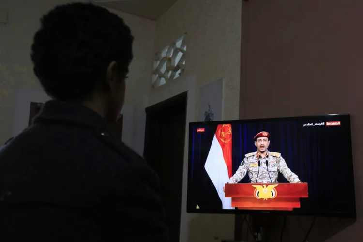 Seseorang menonton pernyataan TV oleh juru bicara militer Houthi Yahya Sarea setelah serangan udara AS-Inggris di Yaman, di Sana'a, Yaman, 12 Januari 2024.