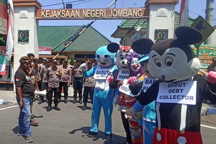Para badut dan aktivis Forum Rembug Masyarakat Jombang (FRMJ) menggelar aksi demonstrasi di Kantor Kejaksaan Negeri (Kejari) Jombang, Jawa Timur, Selasa (17/9/2024).